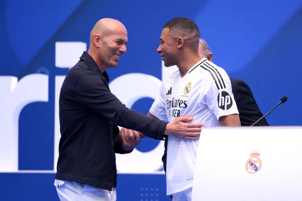 MADRID, SPAIN – JULY 16: Real Madrid new signing, Kylian Mbappe (R) is greeted by former Real Madrid player and coach, Zinedine Zidane as he is unveiled at Estadio Santiago Bernabeu on July 16, 2024 in Madrid, Spain. (Photo by David Ramos/Getty Images)