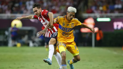 ZAPOPAN, MEXICO – SEPTEMBER 13: Jesús Angulo of Chivas fights for the ball with Raymundo Fulgencio of Tigres during the 9th round match between Chivas and Tigres UANL as part of the Torneo Apertura 2022 Liga MX at Akron Stadium on September 13, 2022 in Zapopan, Mexico. (Photo by Refugio Ruiz/Getty Images)
