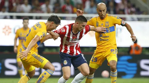 ZAPOPAN, MEXICO - SEPTEMBER 13: Santiago Ormeño of Chivas fights for the ball with Igor Lichnovsky and Guido Pizarro of Tigres during the 9th round match between Chivas and Tigres UANL as part of the Torneo Apertura 2022 Liga MX at Akron Stadium on September 13, 2022 in Zapopan, Mexico. (Photo by Refugio Ruiz/Getty Images)