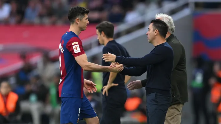 Lewandowski y Xavi se saludan.