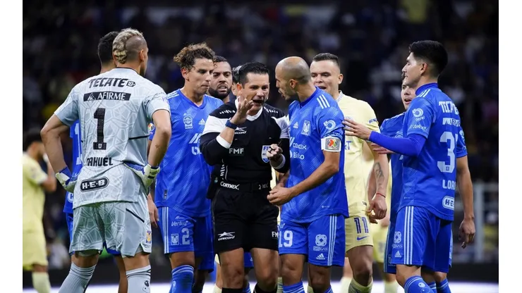El árbitro del encuentro rodeado por los futbolistas de Tigres.
