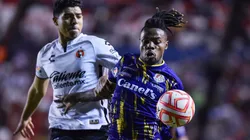 Víctor Guzmán, del Tijuana, persigue a Jhon Murillo, del Atlético de San Luis.