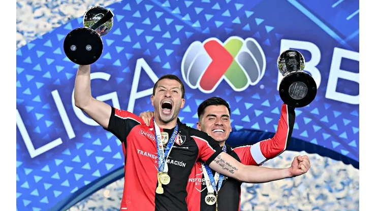 Hugo Nervo y Aldo Rocha levantan los trofeos de campeón.
