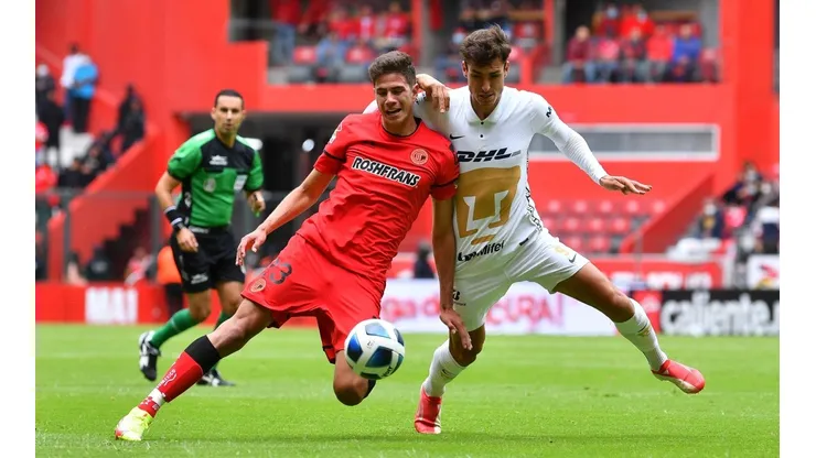 Juan Dinenno en duelo con Haret Ortega, defensa del Toluca.