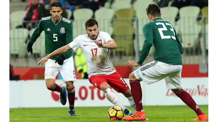 Jakub Kaminski contra Diego Reyes y César Montes en un amistoso entre México y Polonia.