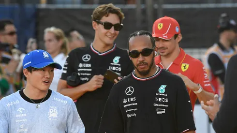 Lewis Hamilton pasea junto a otros pilotos por el paddock