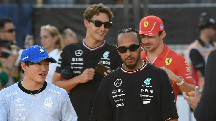 Lewis Hamilton pasea junto a otros pilotos por el paddock