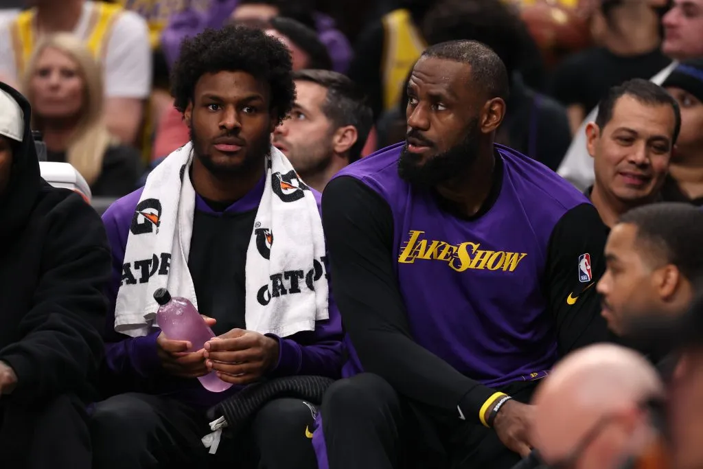Bronny James y LeBron James sentados en la banca de Los Angeles Lakers (GETTY IMAGES)