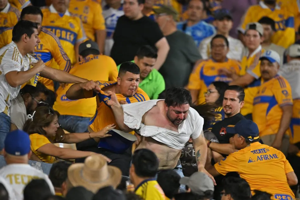 Aficionados de Tigres golpean a un individuo presuntamente identificado con América durante el juego de la quinta jornada del Apertura 2025 en el Estadio Universitario. (Getty Images)