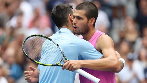 Carlos Alcaraz se abraza con Novak Djokovic tras derrotarlo en la semifinal del US Open.