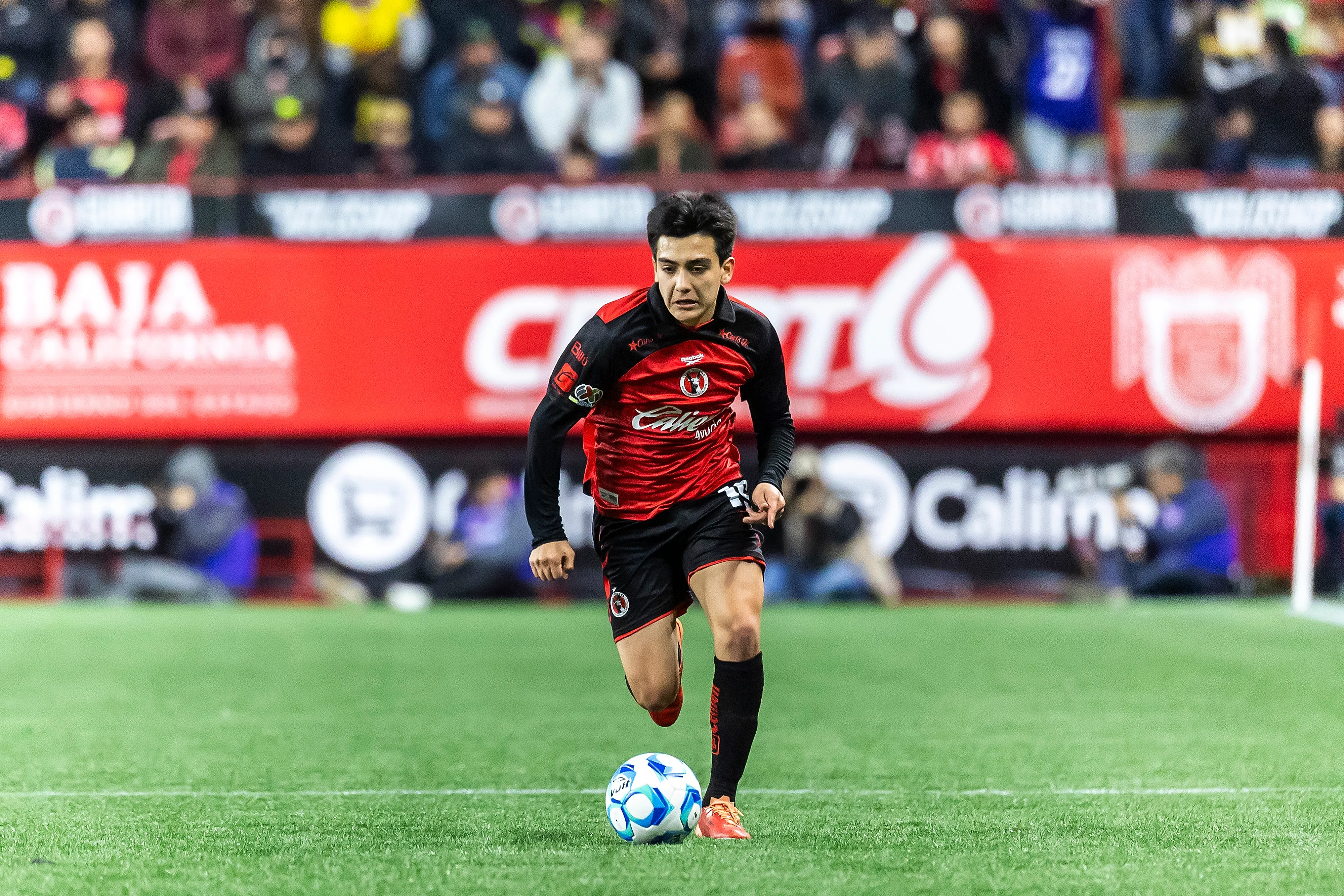 Gilberto Mora conduce el balón con la playera de Tijuana (GETTY IMAGES)