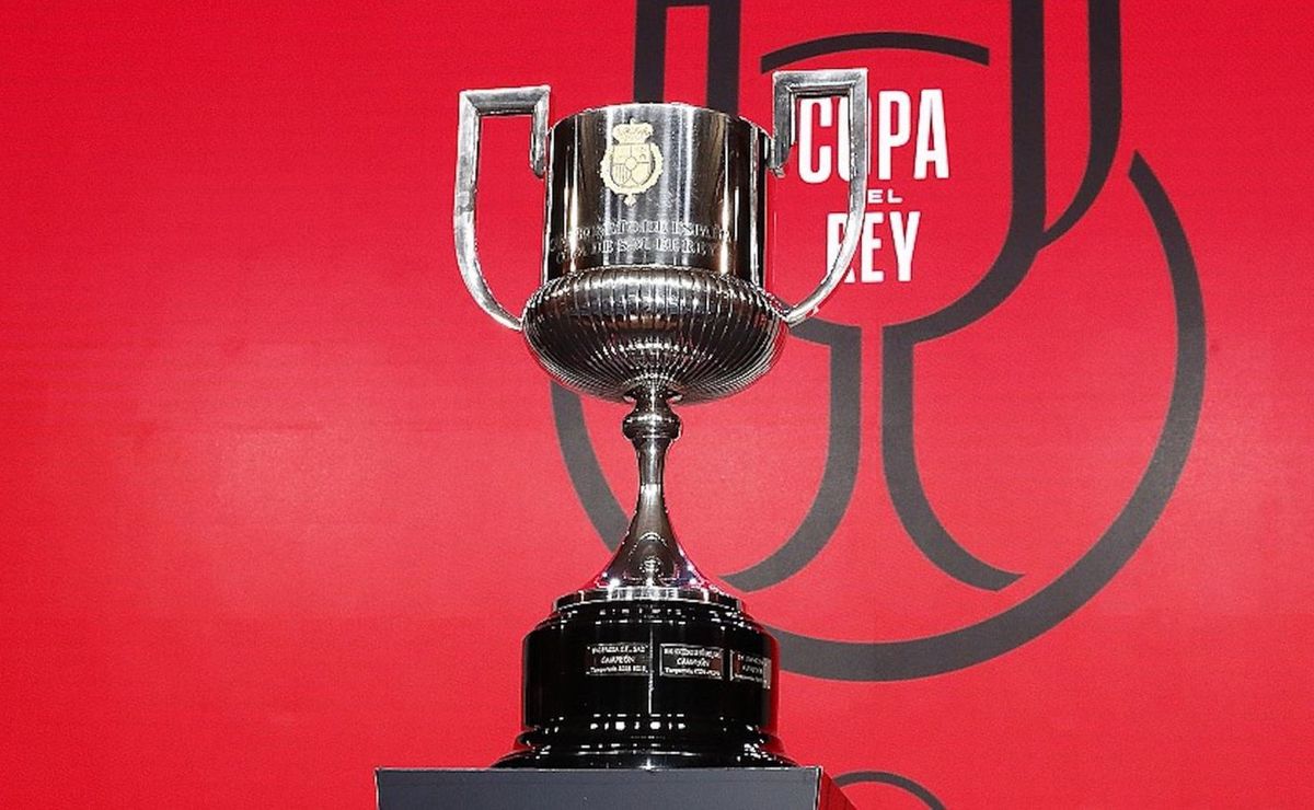 The Copa del Rey trophy on display against a red Copa del Rey backdrop