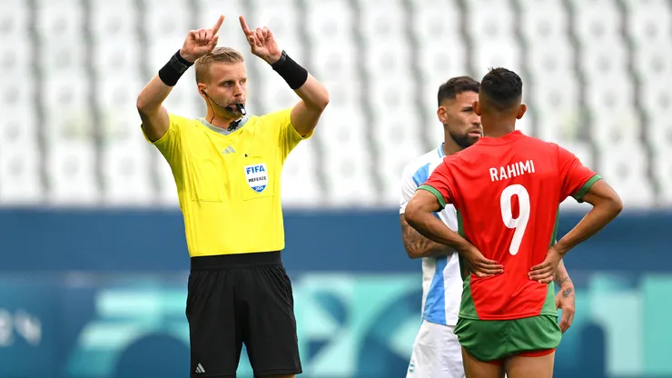 Árbitro de la FIFA realiza la señal del VAR con sus dedos