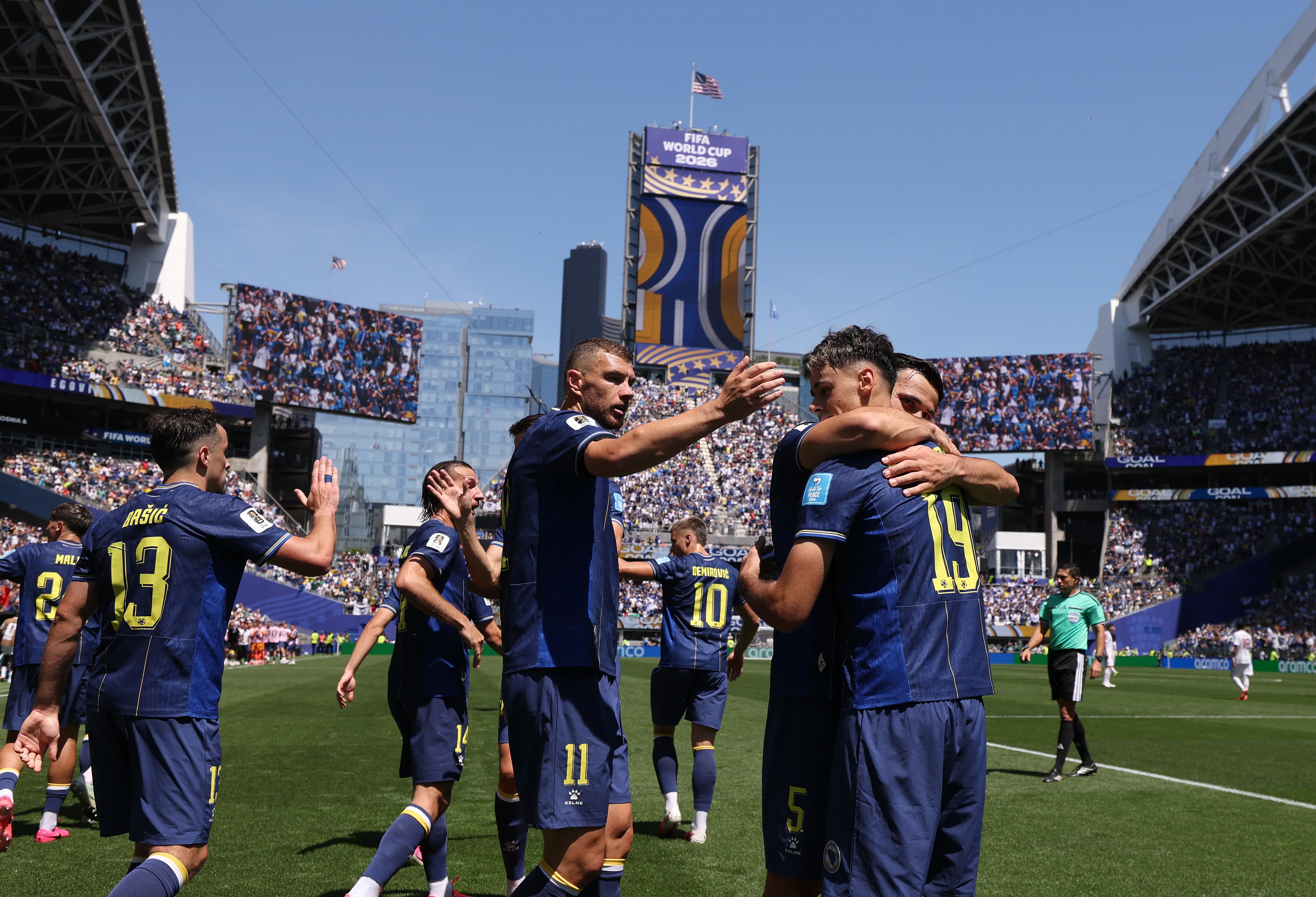 SEATTLE, WASHINGTON – JUNE 24: Kerim Alajbegovic #19 of Bosnia and Herzegovina celebrates with team mates including Edin Dzeko (l) after scoring the team’s first goal during the FIFA World Cup 2026 Group B match between Bosnia and Herzegovina and Qatar at Seattle Stadium on June 24, 2026 in Seattle, Washington. (Photo by Stu Forster/Getty Images)