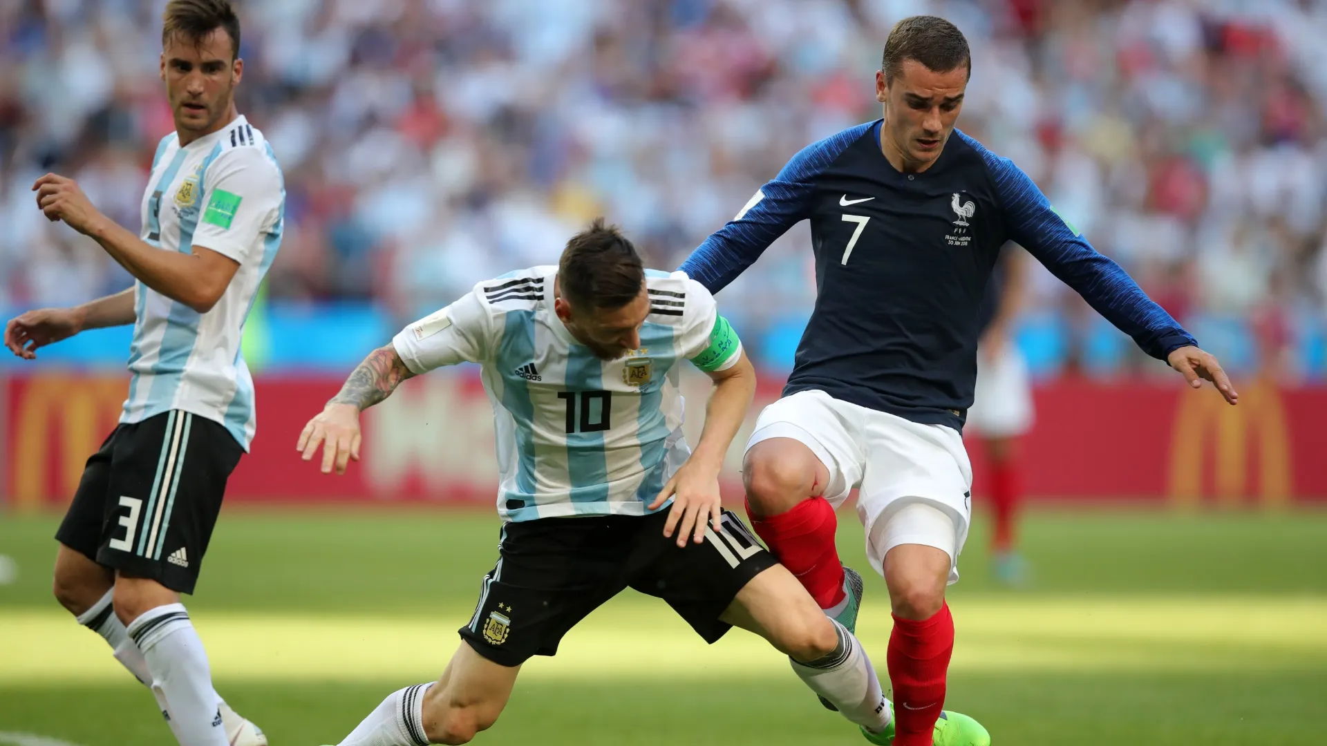 Nicolás Tagliafico y Lionel Messi de Argentina son superados por Antoine Griezmann de Francia en el Mundial 2018.