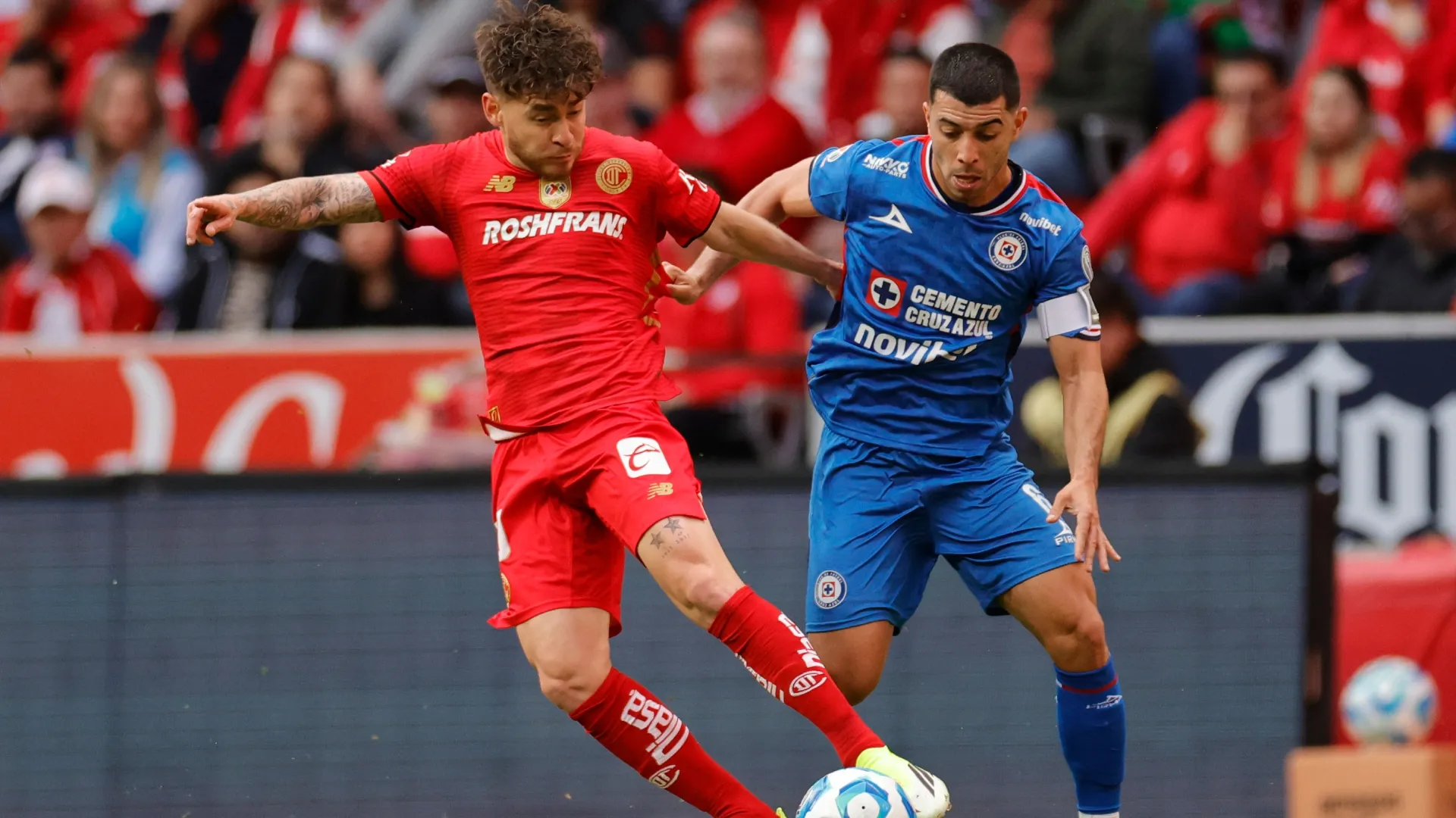 Jesus Angulo de Toluca y Erik Lira de Cruz Azul pelean por la posesión del balón.