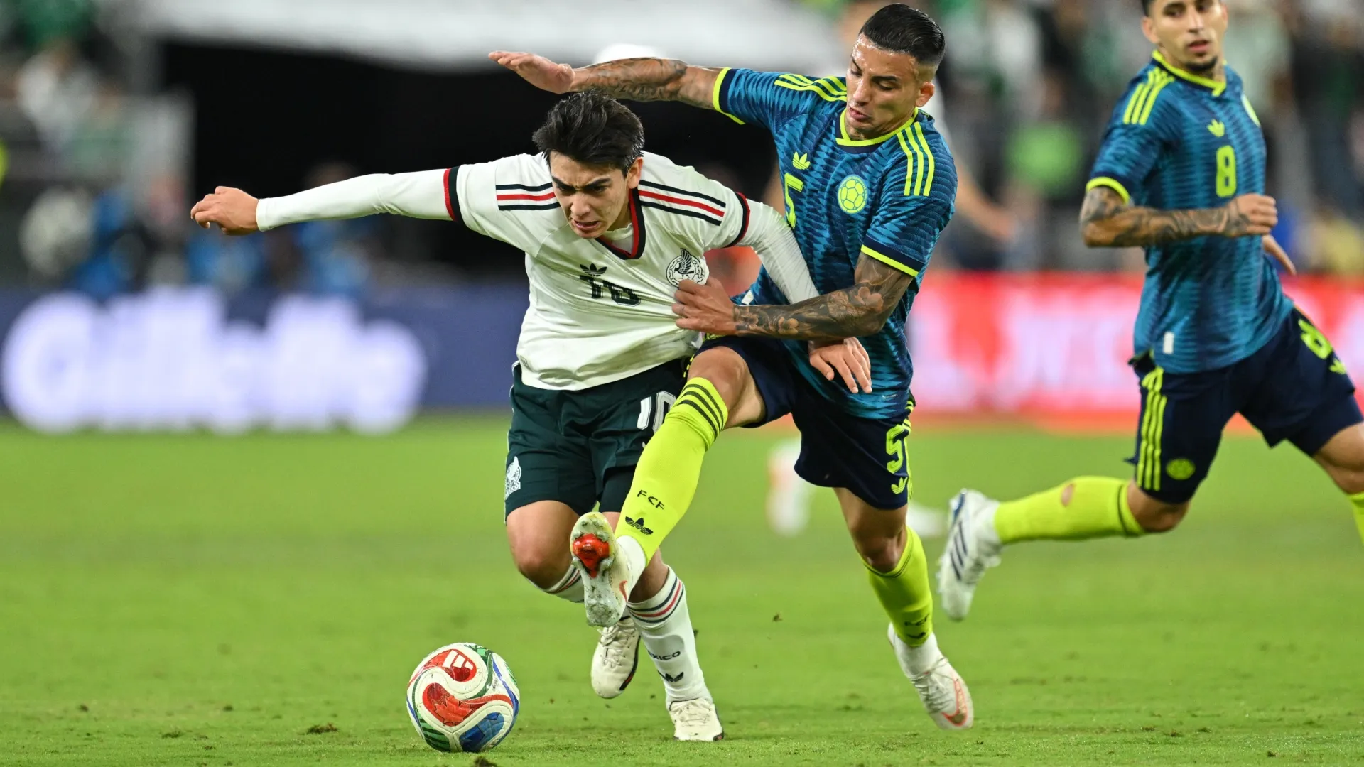 Gilberto Mora lucha por el balón con Kevin Castaño de Colombia.