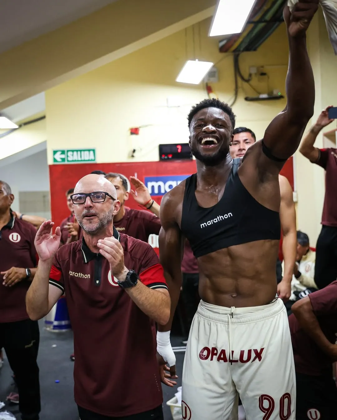 Javier Rabanal y Sekou Gassama festejando el triunfo de Universitario ante Alianza Lima en el vestuario crema en el estadio Monumental. (Foto: Universitario)