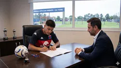 Marco Rivas firmando su contrato profesional.