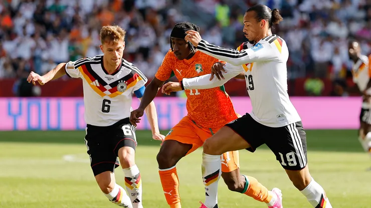 Yan Diomande disputando el balón con Joshua Kimmich y Leroy Sane.