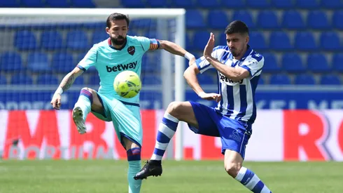 VITORIA-GASTEIZ, SPAIN – MAY 08: Roger of Levante UD battles for possession with Rodrigo Battaglia of Deportivo Alaves during the La Liga Santander match between Deportivo Alavés and Levante UD at Estadio de Mendizorroza on May 08, 2021 in Vitoria-Gasteiz, Spain. Sporting stadiums around Spain remain under strict restrictions due to the Coronavirus Pandemic as Government social distancing laws prohibit fans inside venues resulting in games being played behind closed doors. (Photo by Juan Manuel Serrano Arce/Getty Images)