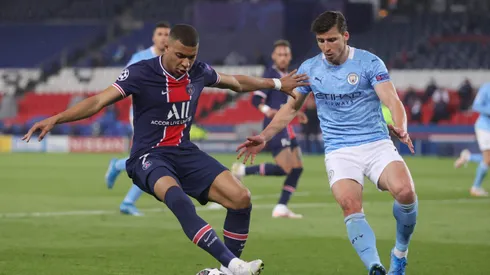PARIS, FRANCE - APRIL 28: Kylian Mbappe of Paris Saint-Germain is challenged by Ruben Dias of Manchester City the ball during the UEFA Champions League Semi Final First Leg match between Paris Saint-Germain and Manchester City at Parc des Princes on April 28, 2021 in Paris, France. Sporting stadiums around France remain under strict restrictions due to the Coronavirus Pandemic as Government social distancing laws prohibit fans inside venues resulting in games being played behind closed doors. (Photo by Alex Grimm/Getty Images)