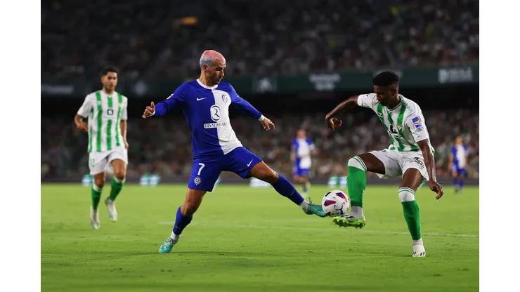 SEVILLE, SPAIN - AUGUST 20: Antoine Griezmann of Atletico Madrid and Abner of Real Betis battle for the ball during the LaLiga EA Sports match between Real Betis and Atletico Madrid at Estadio Benito Villamarin on August 20, 2023 in Seville, Spain. (Photo by Fran Santiago/Getty Images)