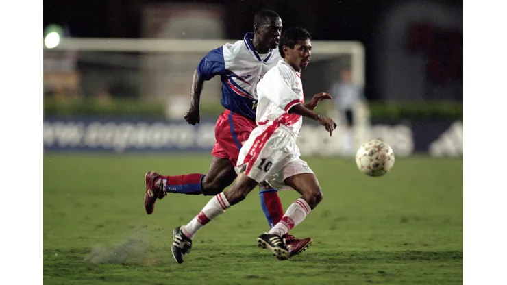 14 Feb 2000: Roberto Palacios #10 of Peru runs with the ball as Wilfred Montilas #14 of Haiti runs next to him during the Gold Cup 2000 Game at the Orange Bowl in Miami, Florida. Team Haiti tied Team Peru 1-1. Mandatory Credit: Andy Lyons /Allsport