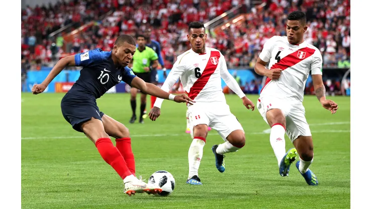 YEKATERINBURG, RUSSIA - JUNE 21: Kylian Mbappe of France crosses the ball under pressure from Miguel Trauco of Peru and Anderson Santamaria of Peru during the 2018 FIFA World Cup Russia group C match between France and Peru at Ekaterinburg Arena on June 21, 2018 in Yekaterinburg, Russia. (Photo by Kevin C. Cox/Getty Images)