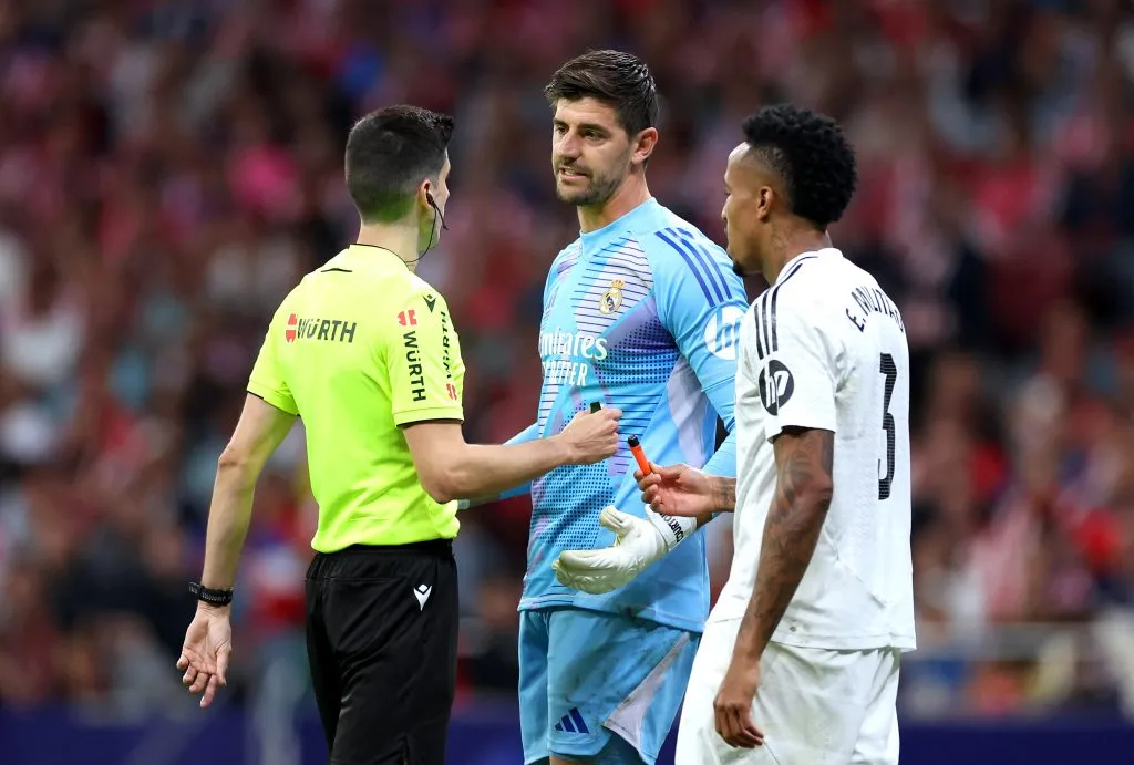 Thibaut Courtois y Éder Militao mostrándole al árbitro los objetos que le arrojaron desde la grada donde se ubicaba el grupo más radical de los aficionados del Atlético de Madrid.