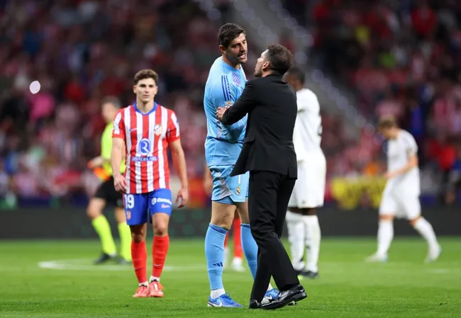 El cruce entre Thibaut Courtois y Diego Simeone en pleno Derbi Madrileño.