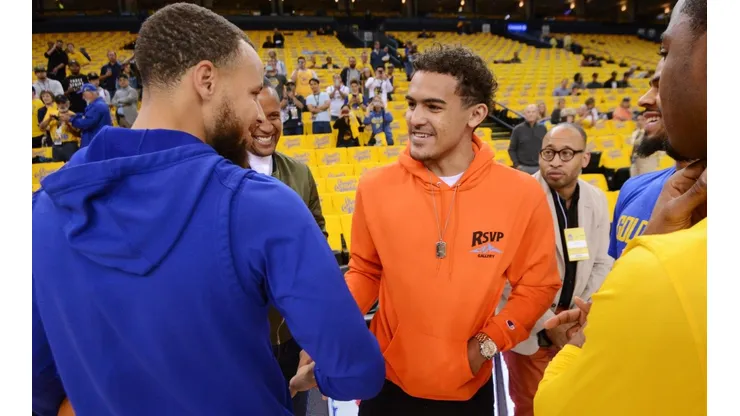 Stephen Curry y Trae Young saludándose.