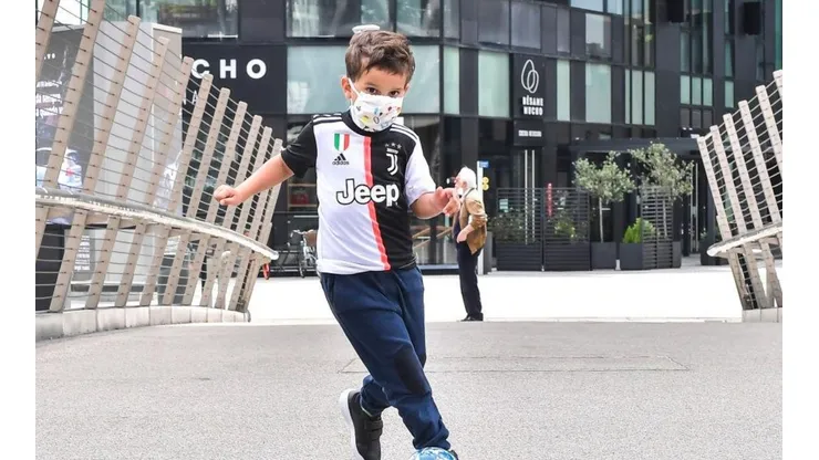 Un pequeño hincha de Juventus jugando al fútbol.