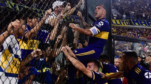 Carlitos Tevez trepándose a uno de los alambrados.