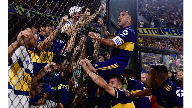Carlitos Tevez trepándose a uno de los alambrados.