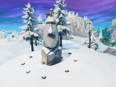 Busca entre una cámara de cine en un sótano, una cabeza de piedra nevada y un gran vehículo de oro llamativo en Fortnite