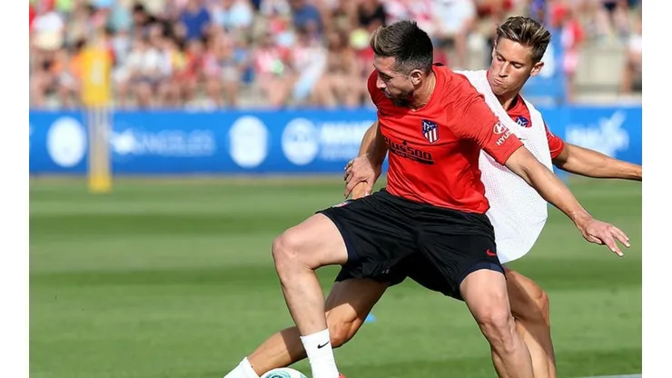 Herrera disputando el balón ante Marcos Llorente. (Foto: sitio oficial Atlético de Madrid)