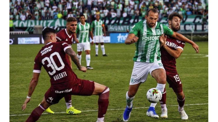 Hrnán Barcos en la disputa de un balón contra dos jugadores de Lanús.