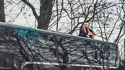 La imagen del joven sentado en el techo del autobús.