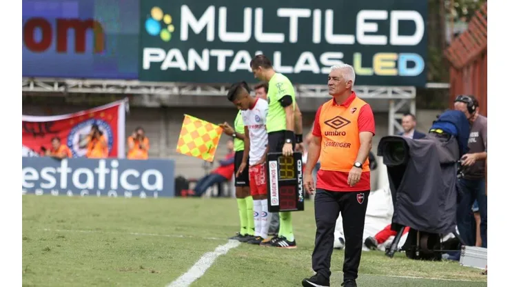 NUEVA RELACIÓN. Omar De Felippe, DT de Newell's, con la publicidad de Multiled de fondo.