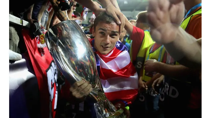 CARIÑO DE CAMPEÓN. Griezmann lleva la Supercopa de Europa entre los hinchas del Atlético Madrid (Foto: Getty).