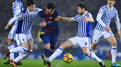 NO LO PUEDEN PARAR. Lionel Messi bajo la lluvia y ante dos jugadores de la Real Sociedad (Foto: Getty).