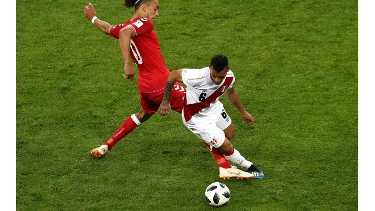 RASPA EN EL MEDIO. Miguel Trauco escapa de la marca en el debut contra Dinamarca con Perú (Foto: Getty).
