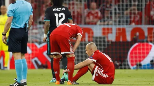 EN EL PISO. Robben se tira al césped sabiendo que ya no podrá volver a jugar en el partido.