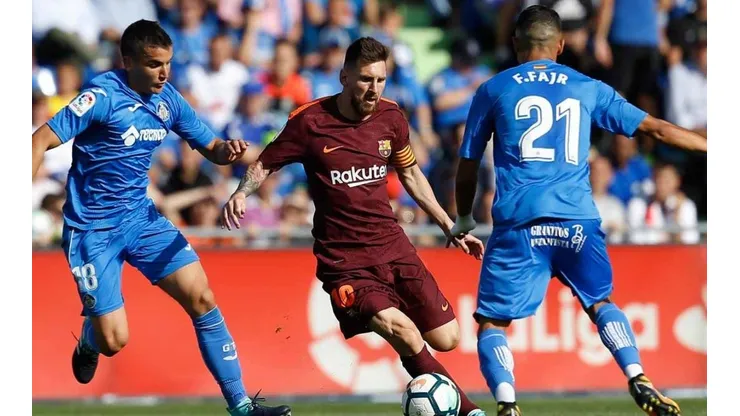 Messi intenta pasar entre dos jugadores de Getafe.