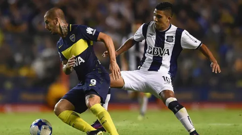 QUIERE SER EL REYNOSO DE LA BOCA. "Bebelo" pelea la pelota con Darío Benedetto, el goleador Xeneize. Ahora, se ilusiona con asistirlo en La Bombonera.