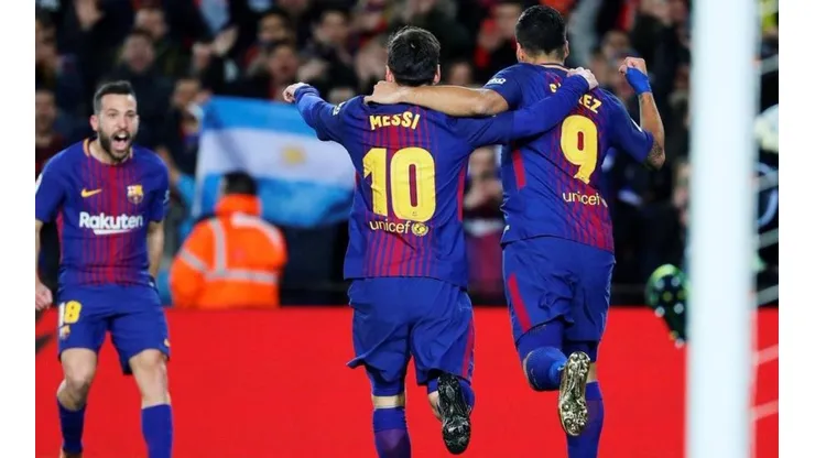 LA MSA. Messi busca a Jordi Alba después de su asistencia y de fondo una bandera argentina.