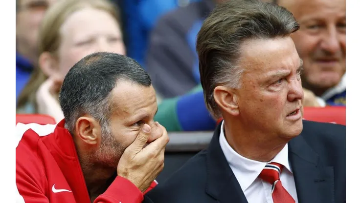 MURMULLOS. Giggs le habla al oído al van Gaal en Old Trafford durante su etapa de asistente técnico.
