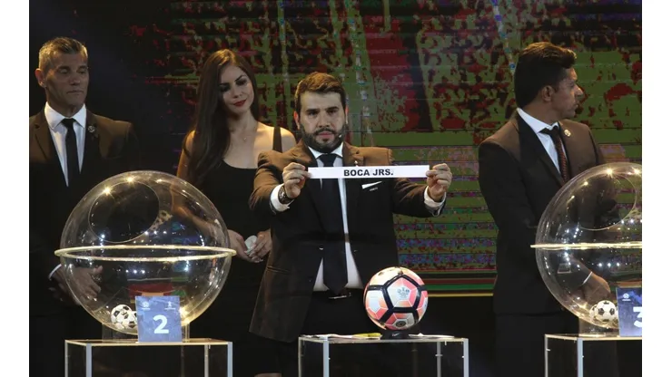 "BOCA JRS". El representante de la CONMEBOL muestra el papelito de Boca para el Grupo 8.
