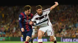 Xabi Alonso disputa el balón con Lionel Messi
